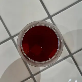 Instagramの投稿：白いタイルの上に置かれた、赤い飲み物のグラスを真上から写した一枚
